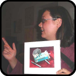 Meghan Hounshell Holding A Kelly Lyles Print With Her Index Finger Extended Meghan Hounshell Holding A Kelly Lyles Print With Her Index Finger Extended