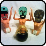 Three Ceramic Skulls About to Eat a Barbie Head