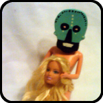 A Ceramic Skull About to Dine on a Barbie Doll Head